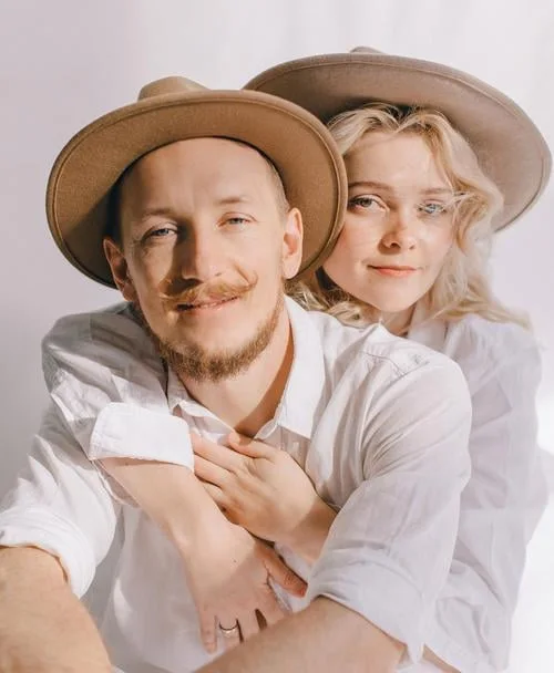 Mikhail and Mila together, wearing hats