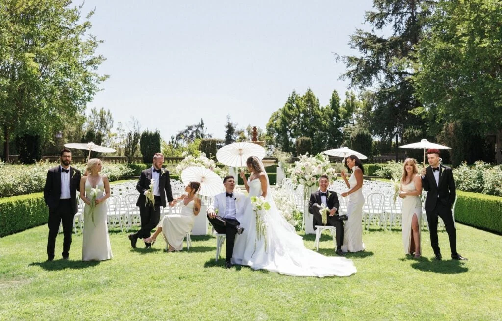 Newlyweds and their wedding guests gathered in a sunlit garden