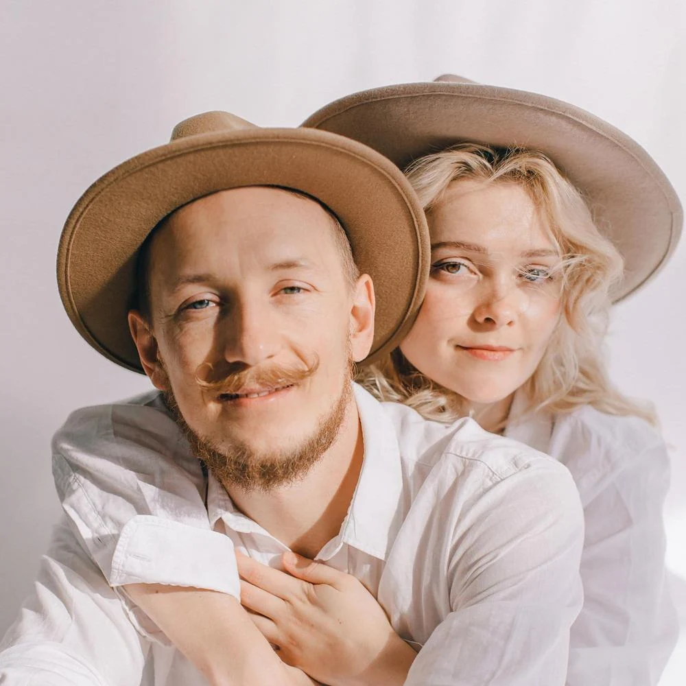 Mikhail and Mila together, wearing hats